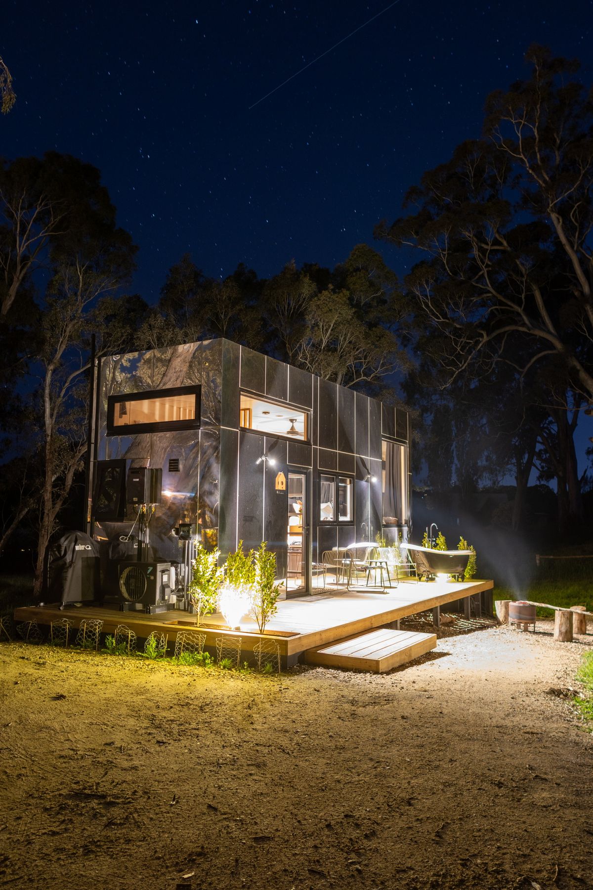 A cabin lit warmly against a deep blue dusk