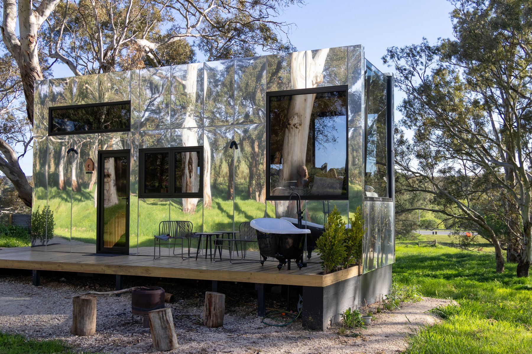 A mirror-clad cabin reflecting the surrounding bush