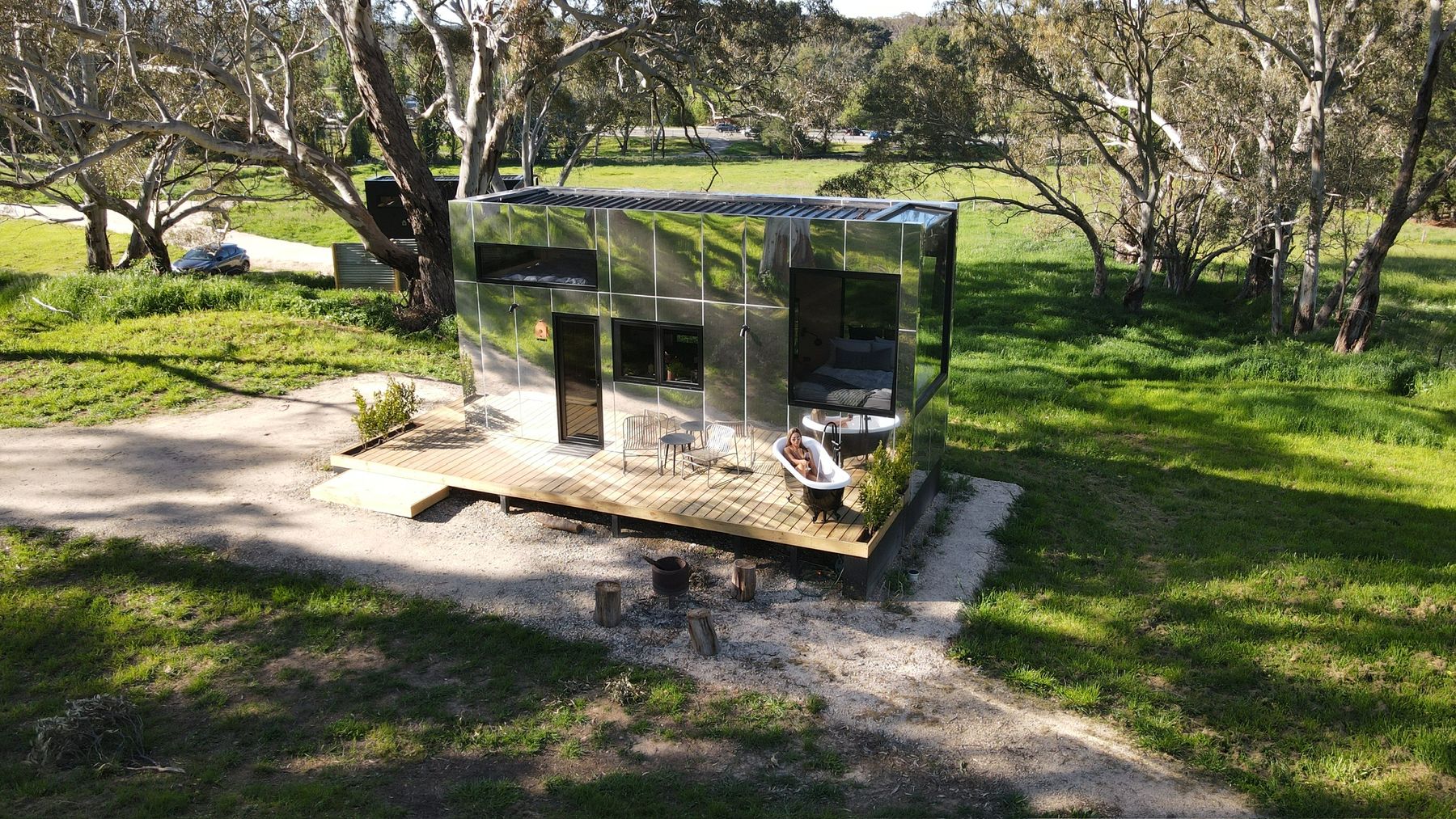 Aerial view of a mirror cabin set in the Australian bush