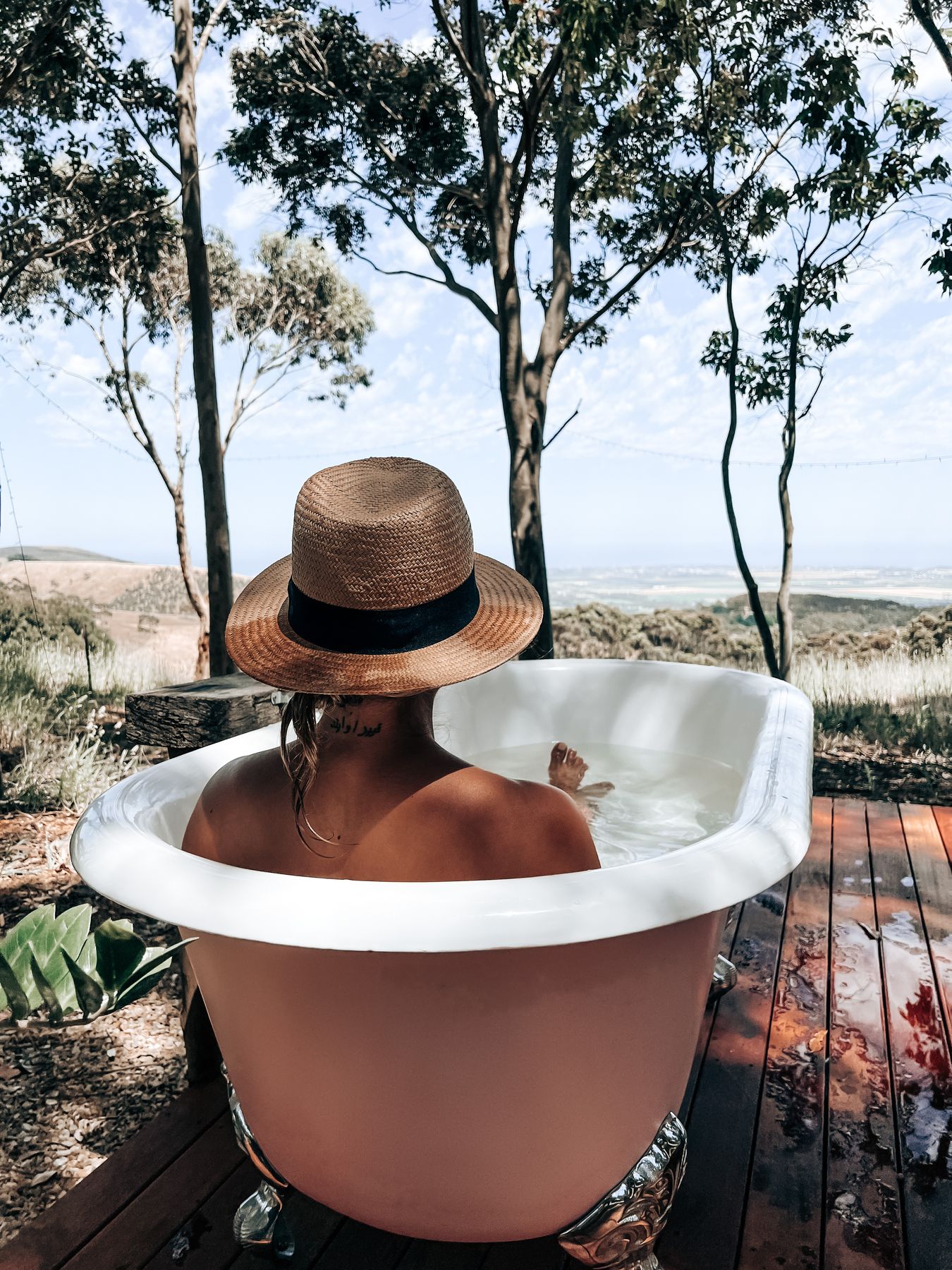 A guest relaxing in an outdoor bath on the deck